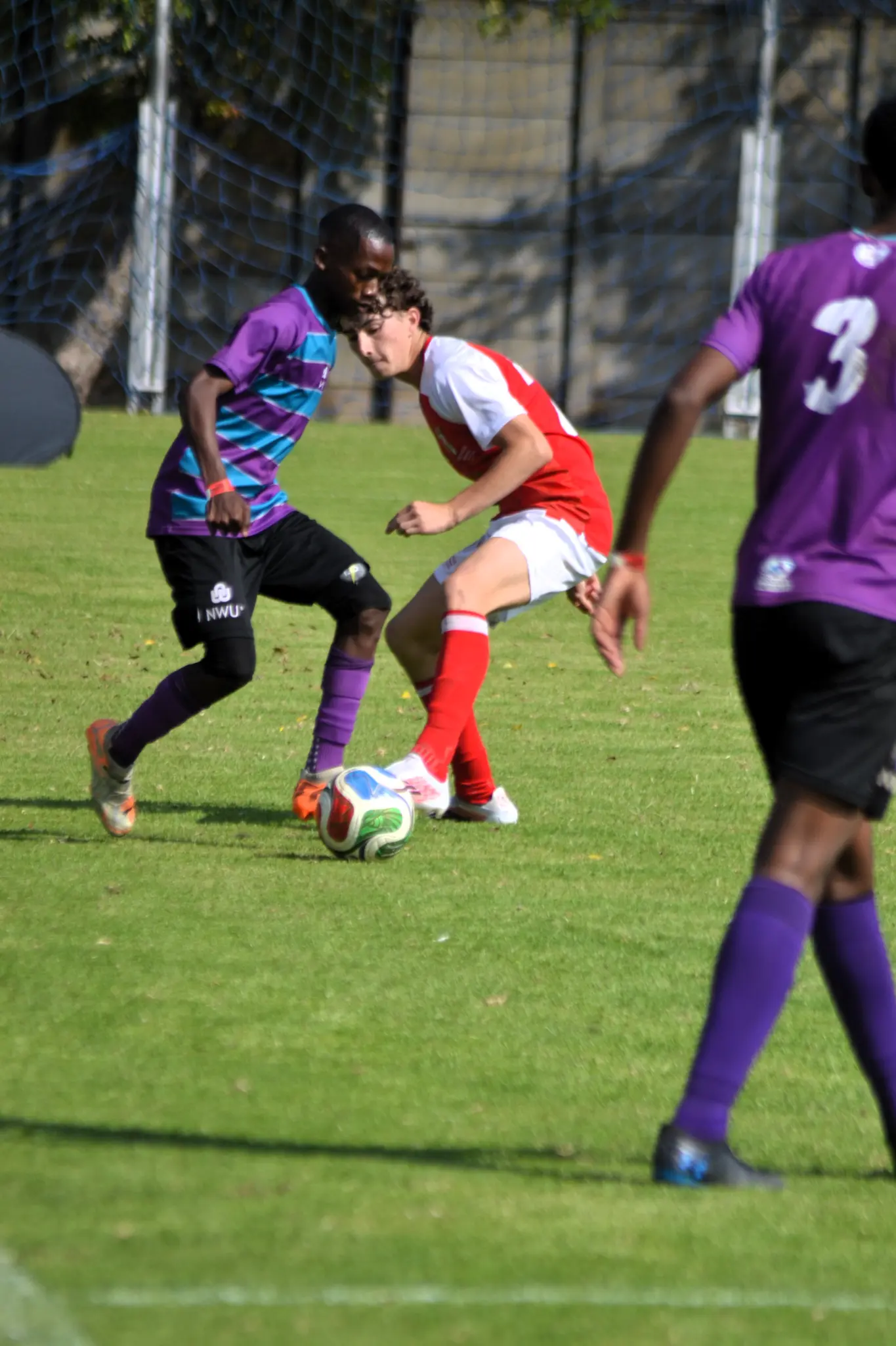 Cameron Harrison shielding the ball under pressure in a Touch Perfect match